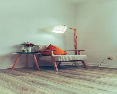 A well-lit reading corner with a comfortable armchair and a warm lamp